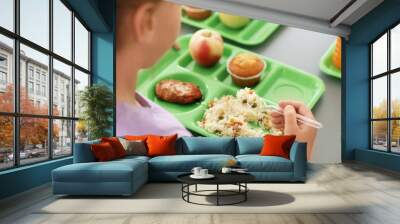 Girl sitting at table and eating healthy food during break at school, closeup Wall mural