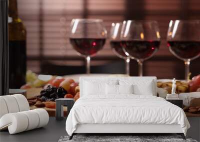 Glasses of red wine and different snacks on table, selective focus Wall mural