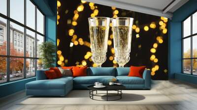 Glasses of sparkling wine and confetti against dark background with blurred lights, closeup. Christmas decor Wall mural