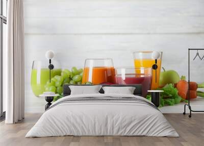 Glasses with different juices and fresh ingredients on table Wall mural