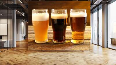 Glasses with different types of beer on wooden table Wall mural