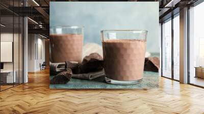 Glasses with tasty chocolate milk on wooden table. Dairy drink Wall mural