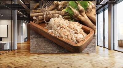 Grated horseradish and roots on wooden table, closeup Wall mural