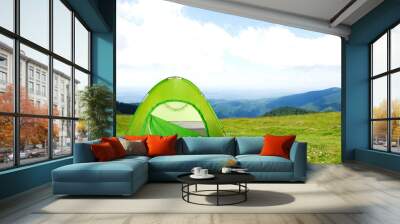 Green camping tent in mountains on sunny day Wall mural