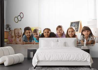 Group of cute little children lying on floor indoors. Kindergarten playtime activities Wall mural