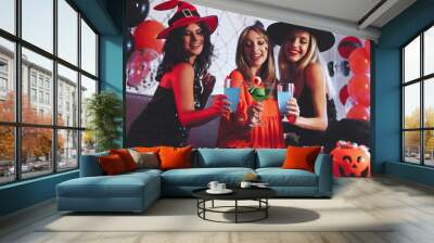 Group of friends toasting with cocktails at Halloween party indoors Wall mural