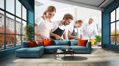 Group of people and male chef at cooking classes Wall mural