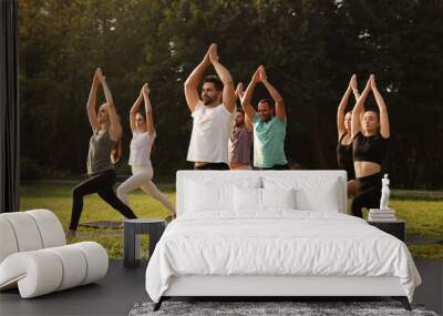 Group of people practicing yoga on mats outdoors Wall mural