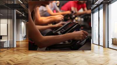 Group of people training on exercise bikes in fitness club, closeup Wall mural