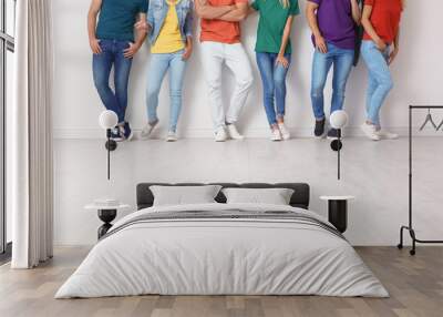 Group of young people in jeans and colorful t-shirts near light wall Wall mural