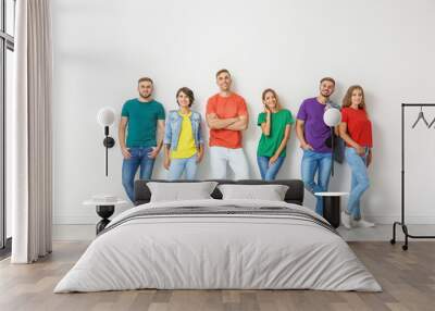 Group of young people in jeans and colorful t-shirts near light wall Wall mural