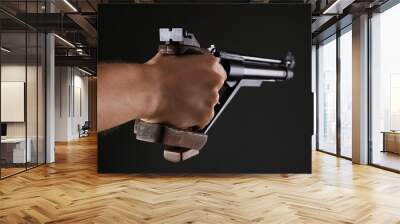 Gun shooting sport. Man aiming standard pistol on dark background, closeup Wall mural