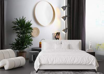 Hallway interior with big round mirror and ottoman chair near white wall Wall mural