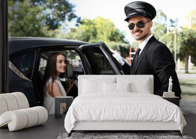 Handsome driver opening car door for young businesswoman. Chauffeur service Wall mural