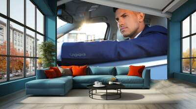 Handsome man in his modern car, view from outside Wall mural