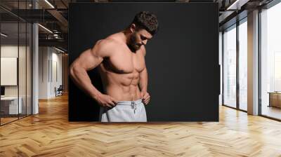 Handsome muscular man on black background, space for text. Sexy body Wall mural