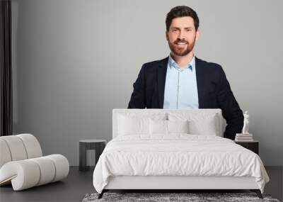 Handsome real estate agent in nice suit on grey background, space for text Wall mural