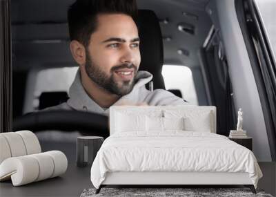 Handsome young man driving his modern car Wall mural