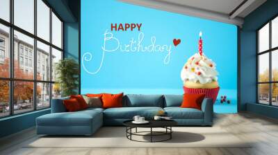 Happy Birthday! Delicious cupcake with candle on light blue background Wall mural