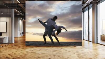 Happy couple dancing on beach at sunset Wall mural