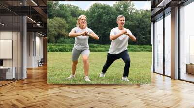 Happy couple doing exercises in park. Healthy lifestyle Wall mural