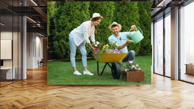 Happy couple working together in green garden Wall mural