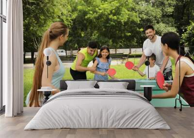 Happy families playing ping pong in park Wall mural