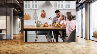 Happy family having breakfast together at table in modern kitchen Wall mural