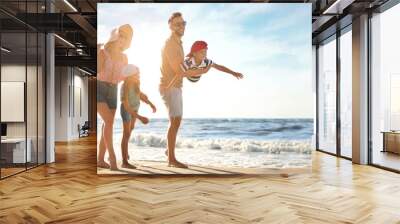 Happy family having fun on sandy beach near sea, space for text. Banner design Wall mural