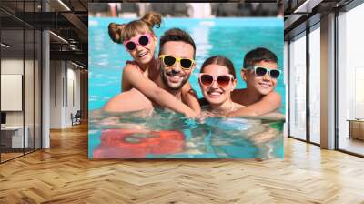 Happy family in swimming pool on sunny day Wall mural