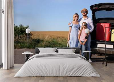 Happy family near car with suitcases outdoors, space for text Wall mural