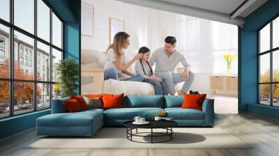 Happy family on sofa and little puppy in living room Wall mural