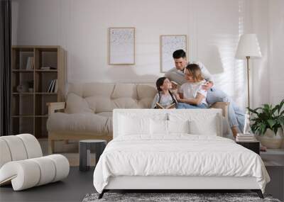 Happy family on sofa and puppy in living room Wall mural