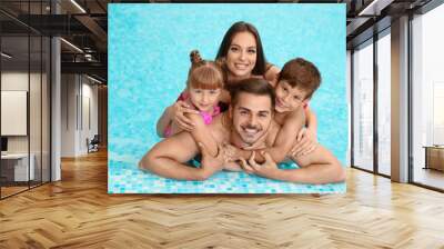 Happy family resting in swimming pool with refreshing water Wall mural