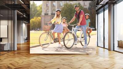 Happy family riding bicycles outdoors on summer day Wall mural