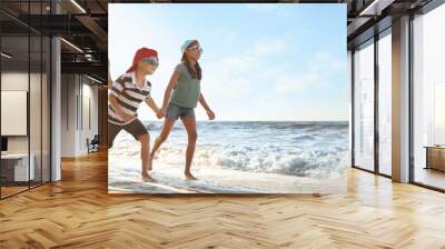 Happy family running on sandy beach near sea, space for text. Banner design Wall mural