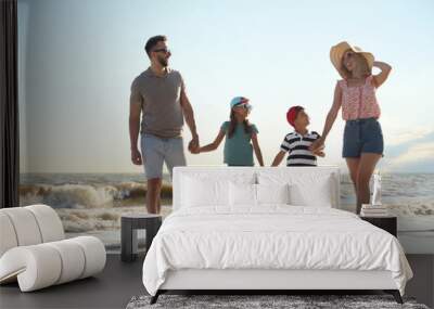 Happy family walking on sandy beach near sea Wall mural