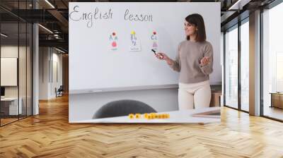 Happy female English teacher giving lesson indoors. Early childhood education Wall mural