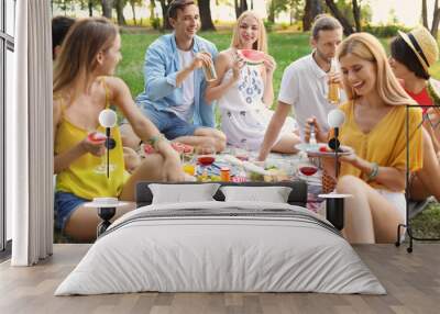 Happy friends having picnic in park on sunny day Wall mural