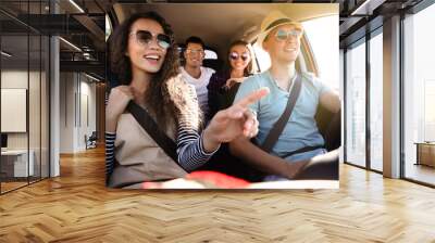 Happy friends together in car on road trip Wall mural