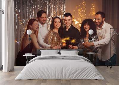 Happy friends with glasses of wine and sparklers celebrating birthday indoors Wall mural