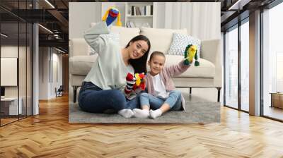 Happy mother and daughter playing with funny sock puppets together at home Wall mural