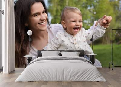 Happy mother with her cute baby in park on sunny day Wall mural