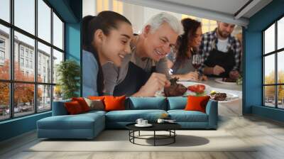 Happy people cooking food together in kitchen Wall mural