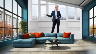 Happy real estate agent showing new apartment Wall mural