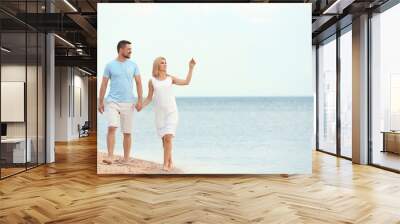 Happy romantic couple walking on beach, space for text Wall mural