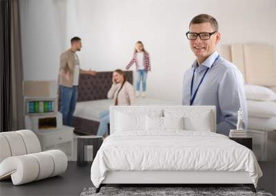 Happy salesman and his clients in mattress store Wall mural