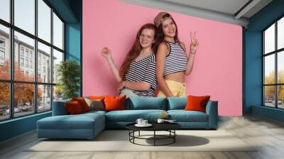 Happy teenage girls posing on pink background Wall mural