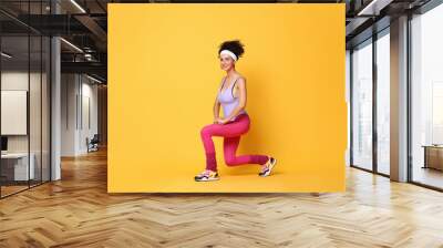 Happy woman doing aerobic exercise on orange background Wall mural