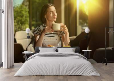 Happy woman having tasty breakfast in cafe on sunny morning Wall mural